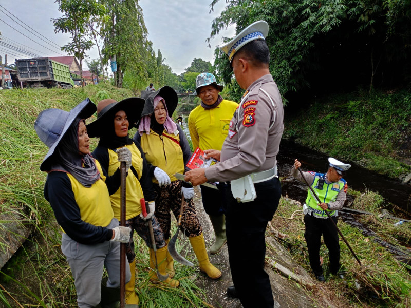 Gotong Royong Atasi Banjir, Ditlantas Polda Riau Sampaikan Pesan Pemilu Damai